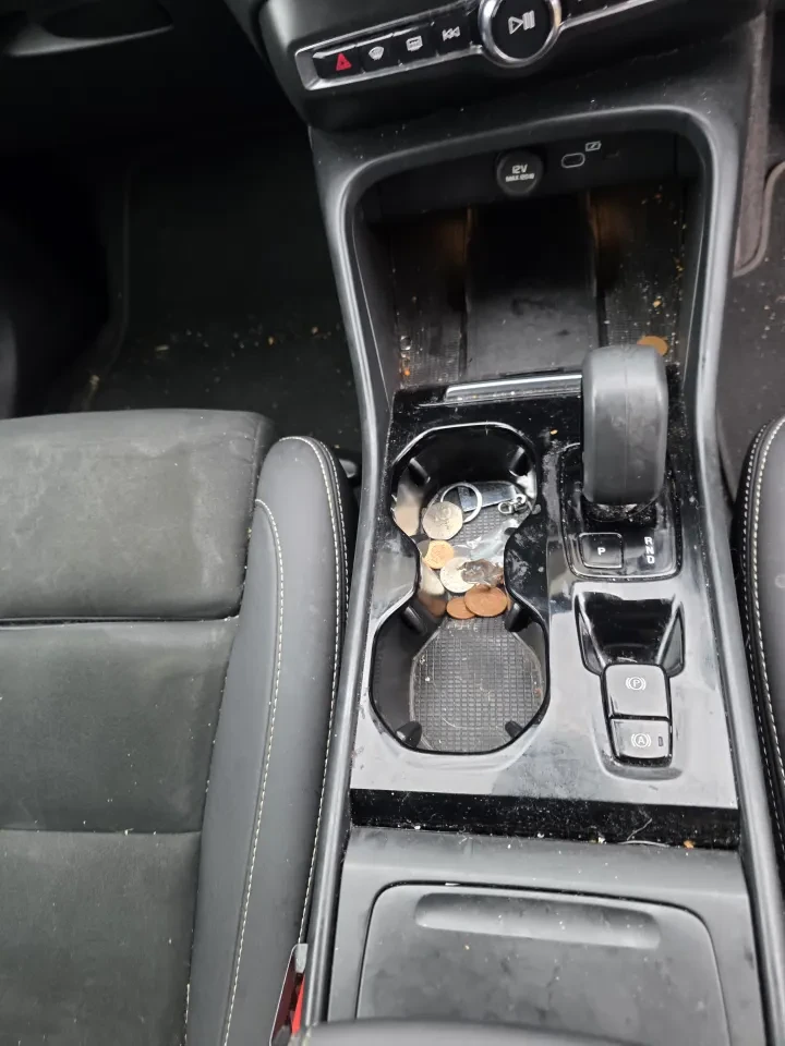 A Volvo XC40 centre console before the valet, with dust and crumbs.