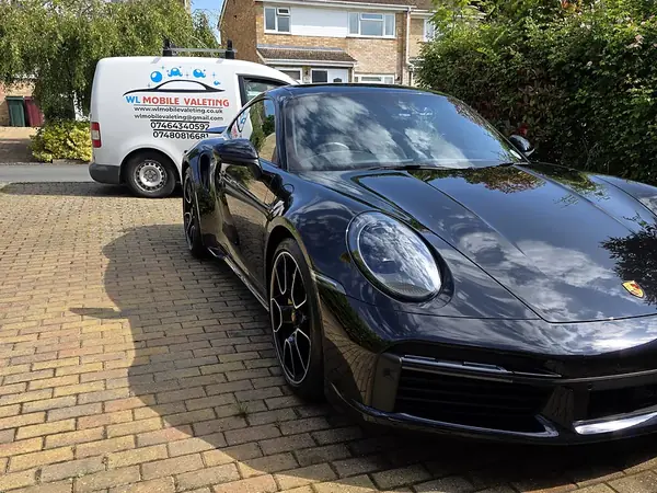 Dark blue Porsche 911 on a block-paved driveway, the WL van behind it.