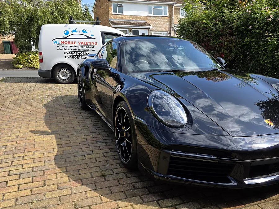 Dark blue Porsche 911 on a block-paved driveway, the WL van behind it.
