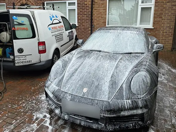 Porsche 911 Turbo S covered in snow foam, the WL van behind it.