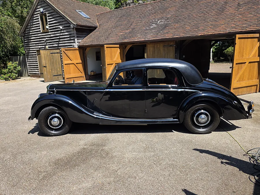 Black classic saloon outside a barn garage after a valet.