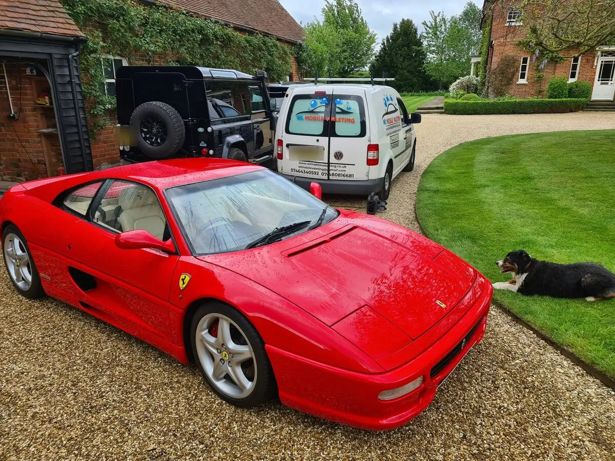 Red Ferrari F355 on a gravel drive, with the WL Mobile Valeting van parked behind it.