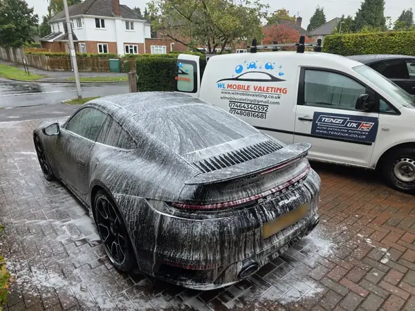 Porsche 911 covered in snow foam, with the WL van behind it.