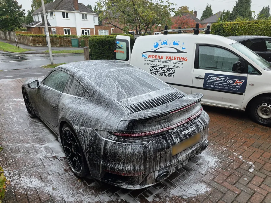 Porsche 911 covered in snow foam, with the WL van behind it.