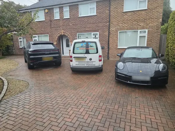 Porsche Cayenne, the WL van and a Porsche 911 lined up on a driveway.