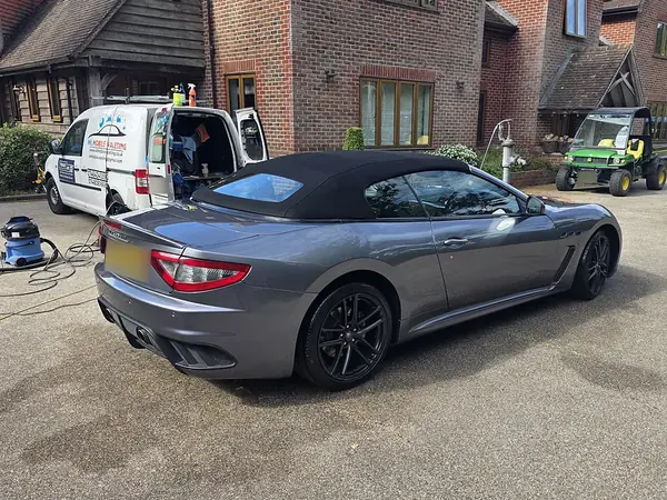 Grey Maserati GranTurismo convertible on a driveway, the WL van behind it.