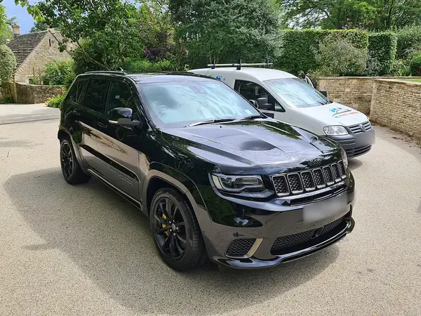 Black Jeep Grand Cherokee Trackhawk from the front, the WL van behind it.