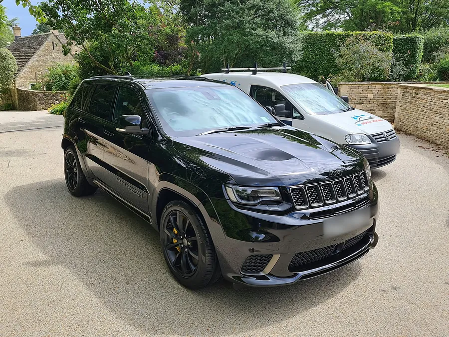 Black Jeep Grand Cherokee Trackhawk from the front, the WL van behind it.