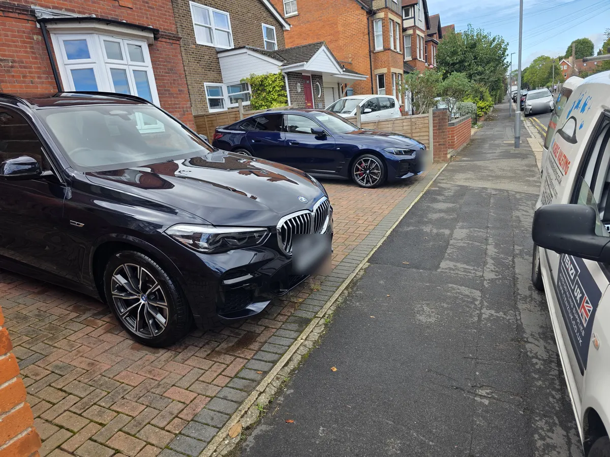 A dark blue BMW SUV and a blue BMW coupé on a brick driveway, with the WL Mobile Valeting van at the kerb.