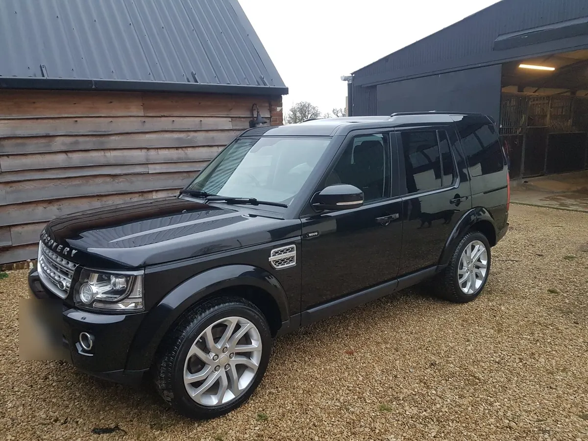 A black Land Rover Discovery on a gravel yard after an exterior valet.