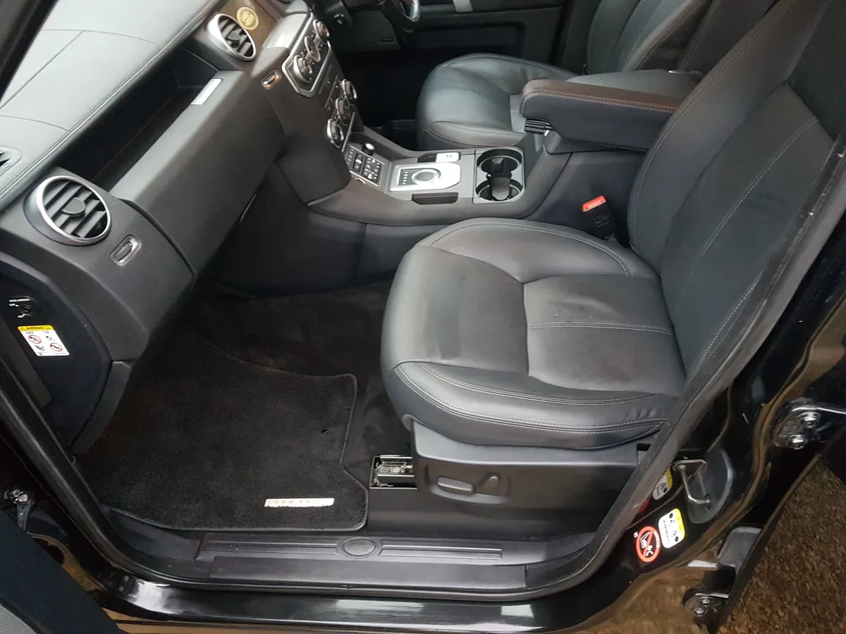 The front passenger seat and footwell of a black Land Rover Discovery after an interior valet.