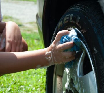 Person washing car well with blue cloth