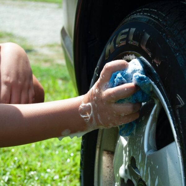 Person washing car well with blue cloth