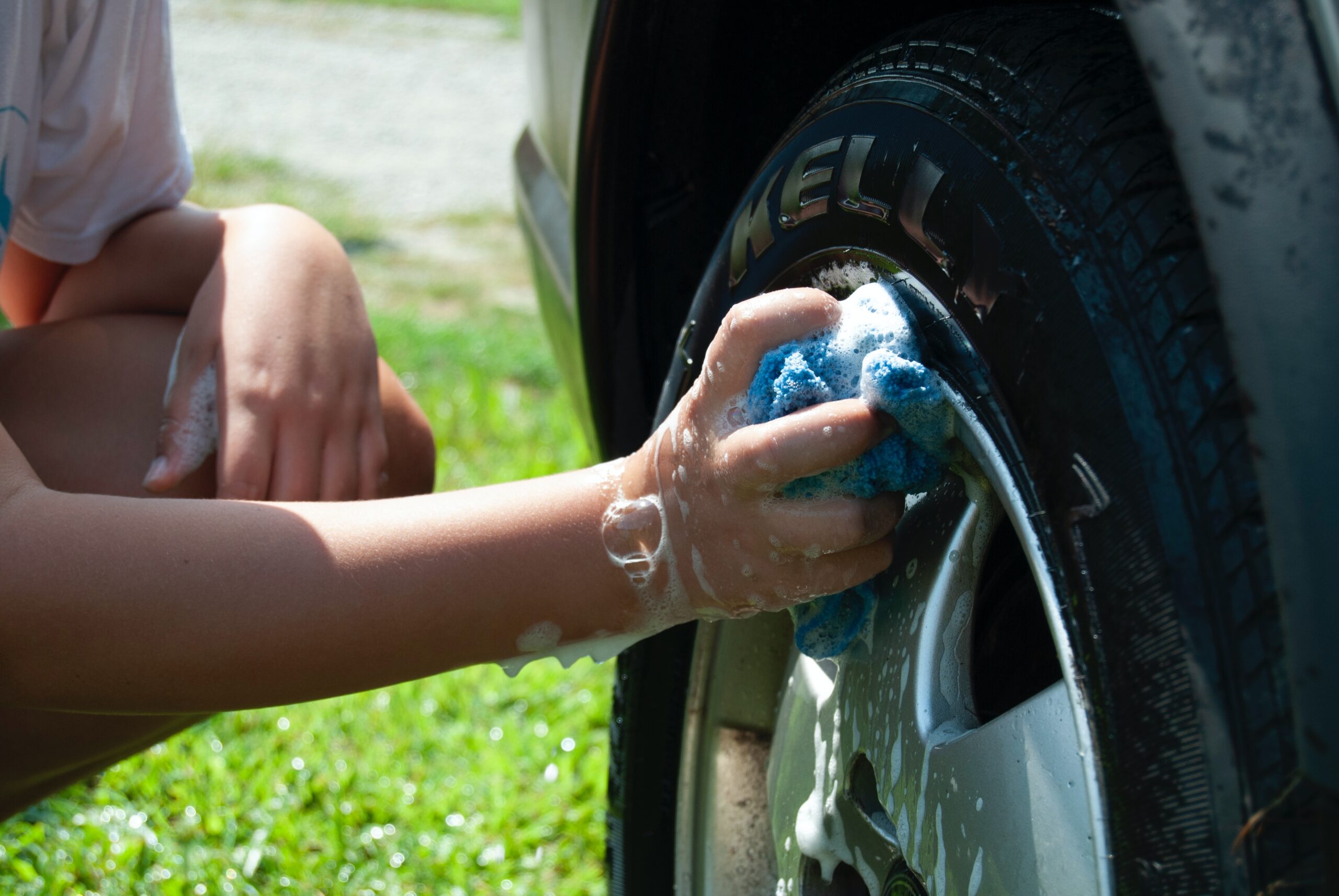 Person washing car well with blue cloth