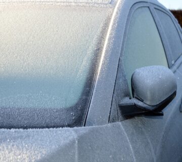 A silver coloured car covered in thick frost over the windows, showing why keeping your car frost free is important