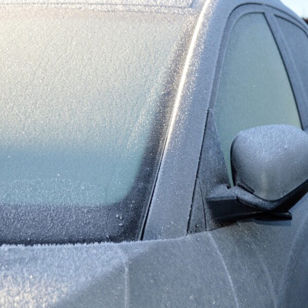 A silver coloured car covered in thick frost over the windows, showing why keeping your car frost free is important