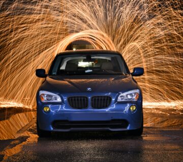 A blue car illuminated from behind by a spinning firework. Celebrating the New Year and time for a new car washing routine.